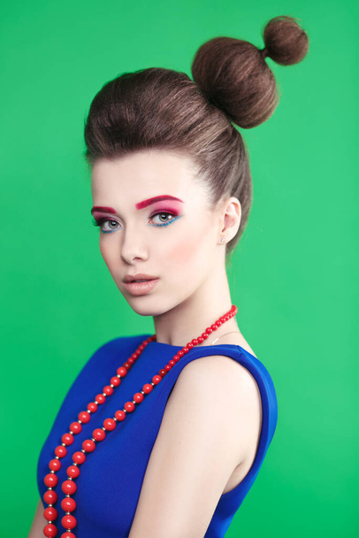 Portrait of a beautiful girl in a blue dress in the style of pin-up and creative hairstyle - Foto, Imagen