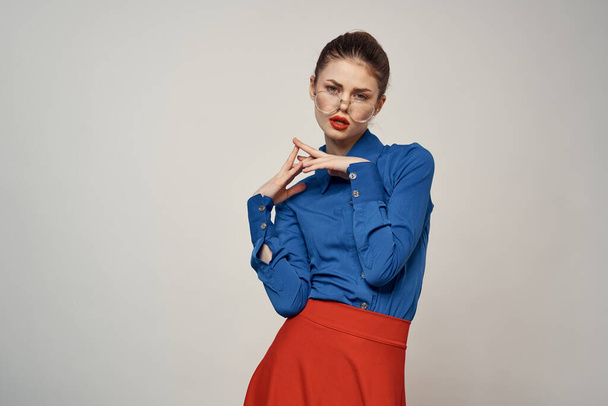 Mavi gömlekli ve kırmızı gözlüklü kadın model. Güzel yüz makyajı stüdyosu. - Fotoğraf, Görsel