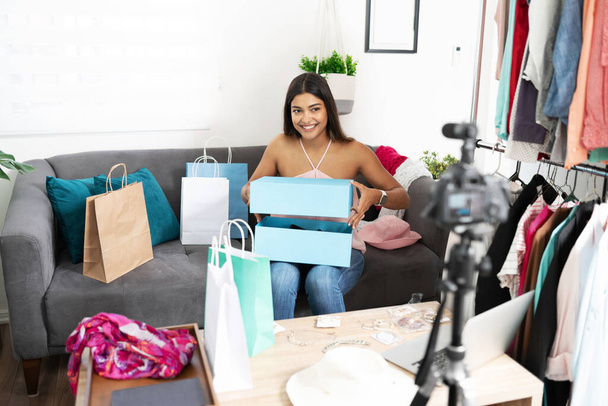 Latin fashion blogger and influencer unboxing a pair of new shoes she just received from one of her clients - 写真・画像