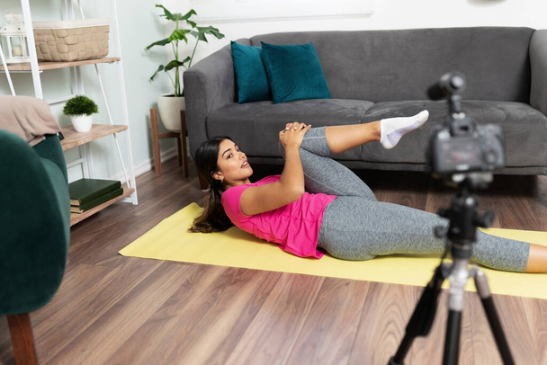 Blogueuse vidéo sur la santé et la condition physique partageant une routine d'entraînement et quelques conseils avec certains de ses abonnés aux médias sociaux - Photo, image