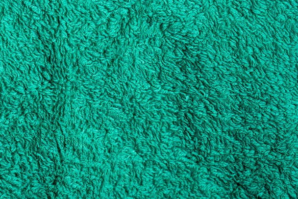 Green, dry Terry towel as a background for the sauna. Green towel for wiping the body. - Photo, Image