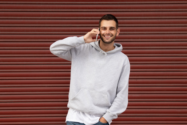 kaupunkien nuori mies rento tyyli matkapuhelin autotallissa sokea - Valokuva, kuva