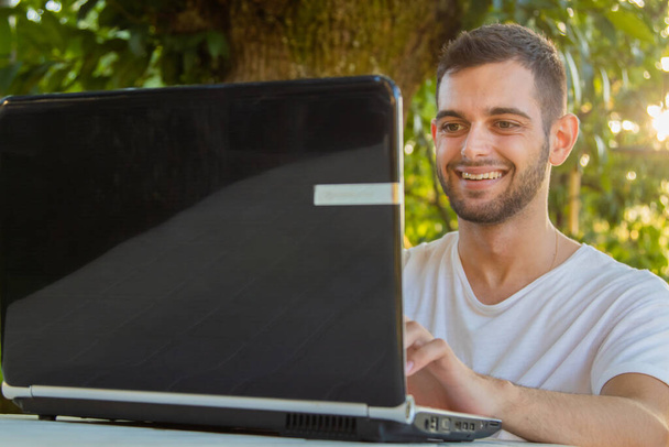 young attractive man working with computer outdoors - Foto, Bild