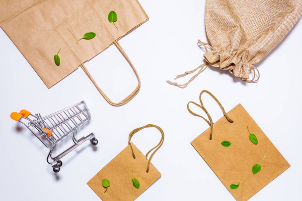 mini shopping cart, eco-friendly paper bag for shopping in hypermarkets on white. top view - Photo, Image