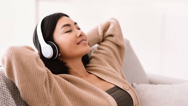Mulher asiática ouvindo música usando fones de ouvido - Foto, Imagem