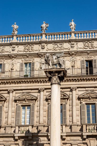 Verona, Piazza delle Erbe utca. Ősi Maffei palota barokk stílusban 1626-1663 és a szárnyas Szt. Márk Oroszlán jelképe a Velencei Köztársaság és Mark a vándor. Veneto, Olaszország, Európa. - Fotó, kép