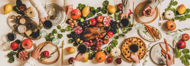 Autumn Thanksgiving, Friendsgiving, family party dinner. Flat-lay of peoples hands with wineglasses celebrating over table with roasted duck, vegetables, cheese board and apple pie, top view - Foto, afbeelding