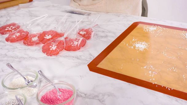 Wrapping large homemade lollipops into clear gift bags. - Photo, Image