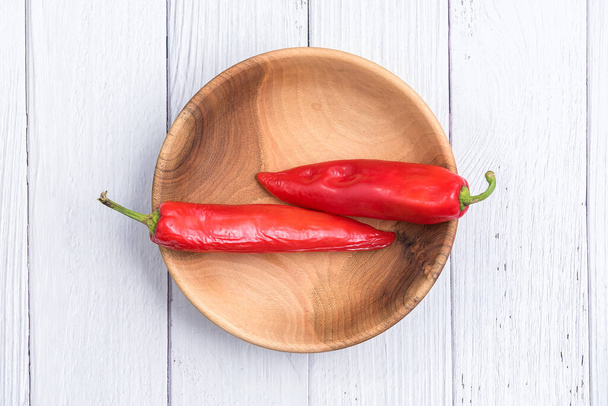 Red raw chili peppers in a wooden bowl. Ripe peppers Close up. Copy space. - Фото, зображення
