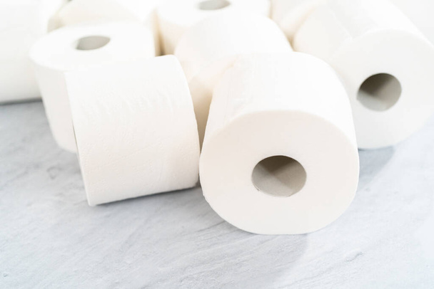 Новые белые рулоны туалетной бумаги на сером фоне. - Фото, изображение