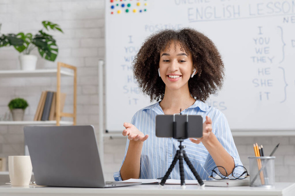 Evde yalnızlık çeken öğrenciler için çevrimiçi İngilizce dersi. Mutlu Afrikalı Amerikalı kadın web kamerasına bakıyor. - Fotoğraf, Görsel