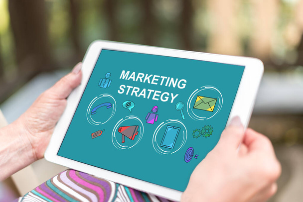 Female hands holding a tablet with marketing strategy concept - Photo, Image
