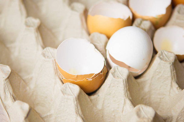 Bir sürü kabuk yumurtası karton yumurtaya saçılmış. - Fotoğraf, Görsel