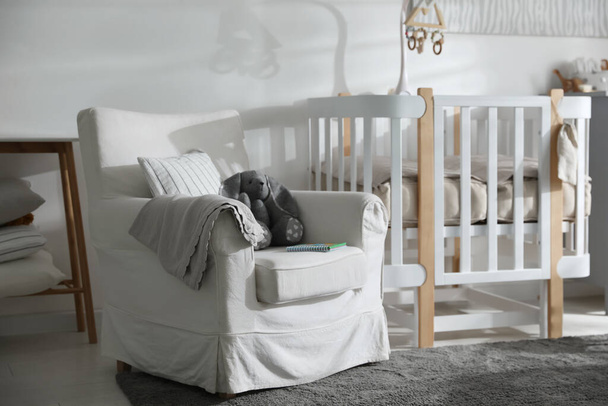 Baby room interior with crib and armchair. Idea for design - Фото, зображення