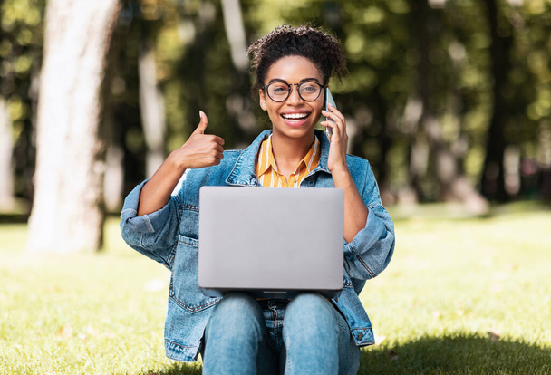 African Student Woman With Laptop Gesturing Thumbs Up Sitting Outside - Photo, Image