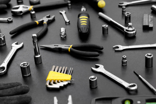 Muitas ferramentas diferentes para trabalhos de reparação em um fundo preto. Conceito de reparação e construção. - Foto, Imagem