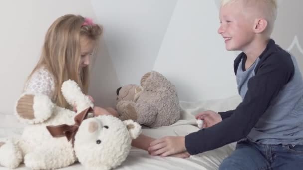 Netter Bruder und Schwester spielen zusammen zu Hause mit Teddybären - Filmmaterial, Video