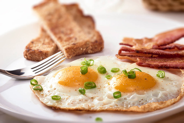 Fried eggs on a plate with bacon and toast - Photo, Image