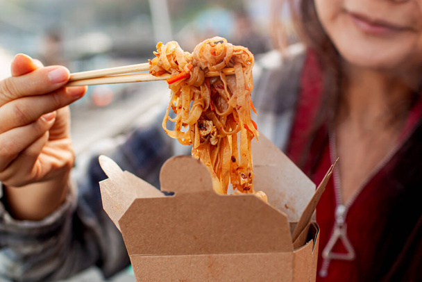 Asian Woman Holding A Street Food in city. - 写真・画像