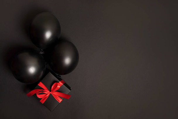 Vente vendredi noir plat laïc avec boîte cadeau et ballons, fond avec espace de copie - Photo, image