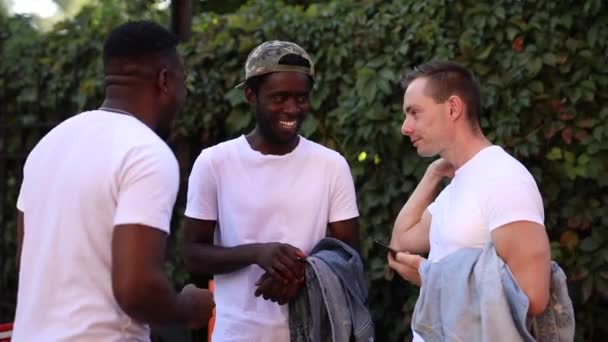 Drie multiraciale vrienden chatten en lachen in de straat - Video