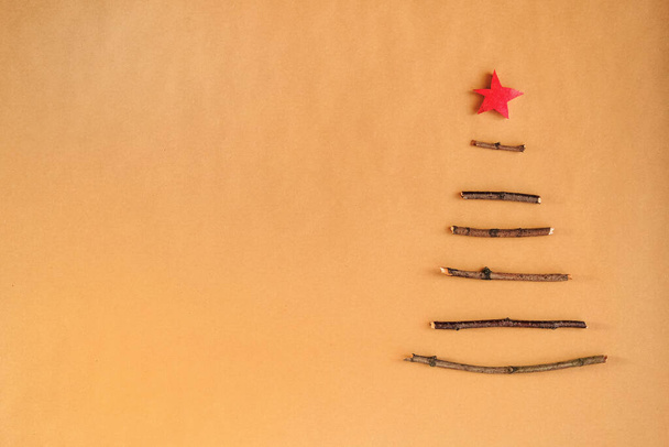 Arbre de Noël écologique créatif fait de bâtons de bois et de fruits secs et de cônes de pin. Conception minimale sur fond de papier artisanal. - Photo, image