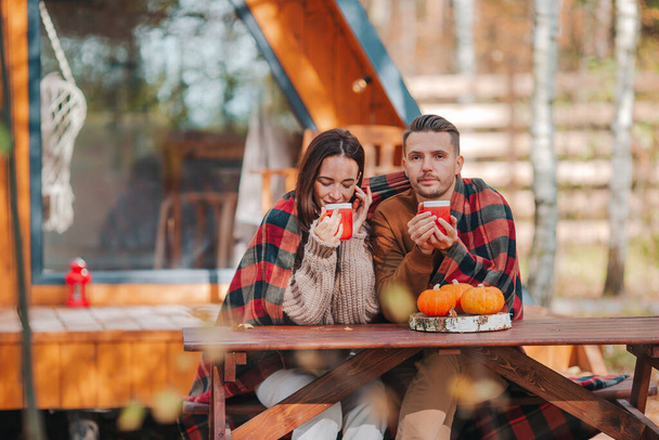 Junges Paar mit Kaffee auf Hof ihres Hauses im Herbst - Foto, Bild