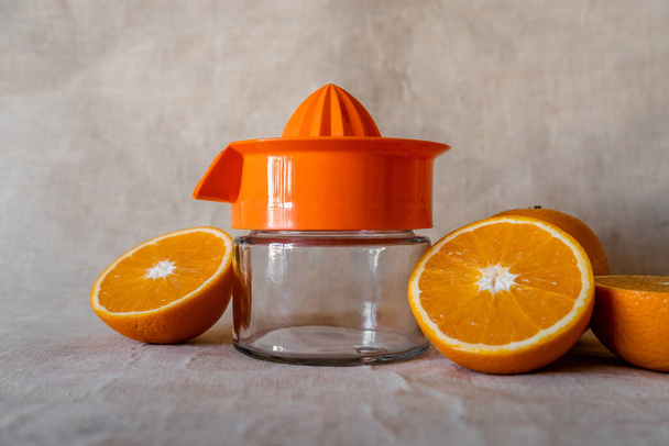 Manual glass juicer with oranges cut in half on the sides - Photo, Image