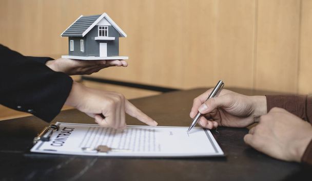 Real estate agent or sales manager has proposed terms and conditions to customers who sign house purchase agreements with insurance, Agreement to sign the purchase contract concept. - Photo, Image