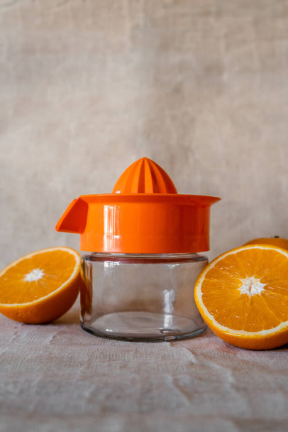 Χειροκίνητος αποχυμωτής με πορτοκάλια κομμένα στη μέση. Κάθετη βολή. - Φωτογραφία, εικόνα