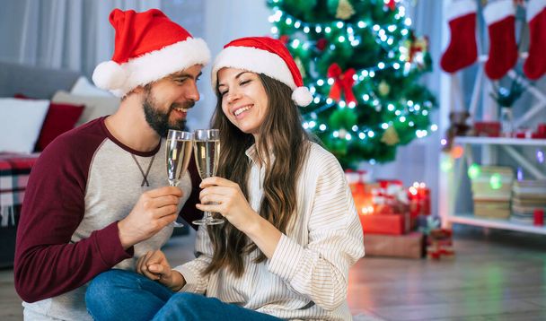 Happy couple in love are celebrating Christmas holidays together and having fun at home - Foto, Imagem