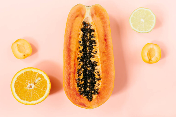 Summer tropical composition. Tropical fruits Papaya, orange, lemon, peach on pink background. Summer concept. Flat lay, top view, copy space. High quality photo - Fotó, kép