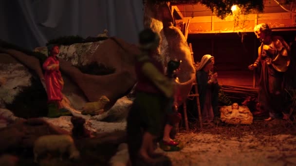 Kerststal van de geboorte van baby Jezus gemaakt van hout in donkere kleuren, verlicht - Video