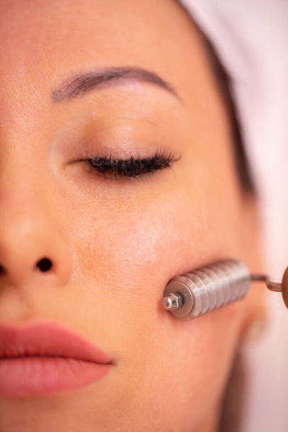 Facial madero massage with a face roller, woman in beauty salon close up - Fotografie, Obrázek