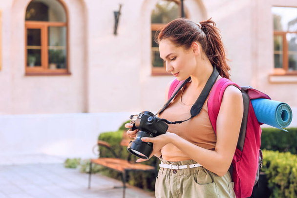 Female tourist with camera on city street - Foto, imagen
