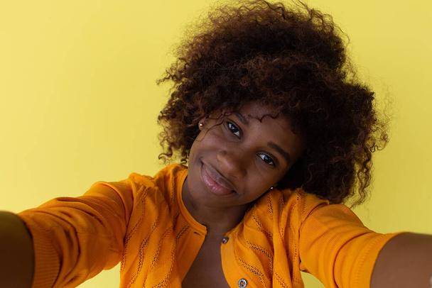 el Afroamericano Feliz se toma la selfie sobre el fondo amarillo - Foto, Imagen