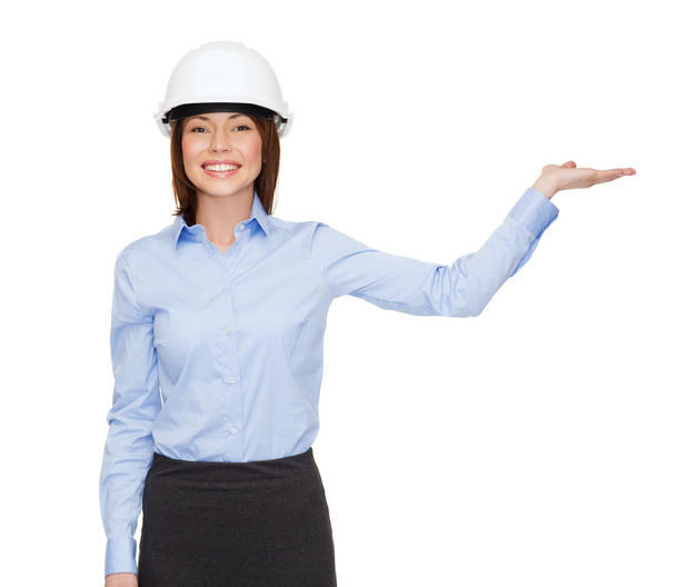 Businesswoman in helmet holding something on palm - Foto, imagen