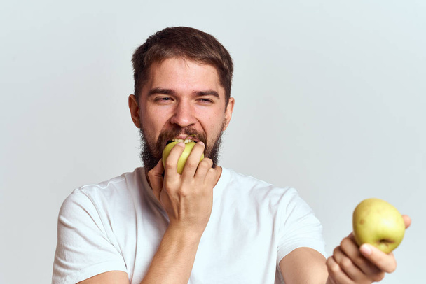 Homme énergique avec pommes santé vitamines alimentation et mode de vie blanc t-shirt vue recadrée - Photo, image