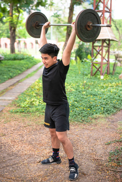Asain chlap zvedání váhy zvýšit činku nad hlavu - Fotografie, Obrázek