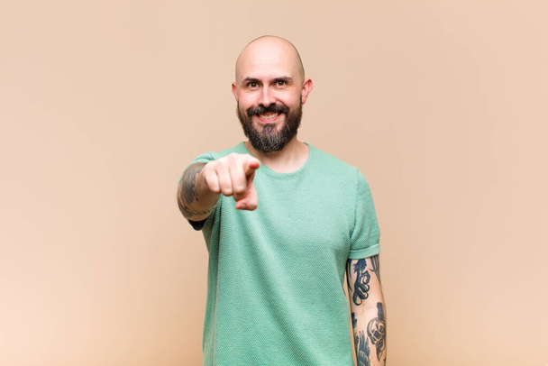 young bald and bearded man pointing at camera with a satisfied, confident, friendly smile, choosing you - 写真・画像