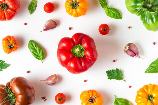 Tomate, poivre, basilic, épices, ail. Alimentation végétalienne. Composition créative sur fond blanc. Concept de cuisson de légumes biologiques. vue de dessus. pose plate - Photo, image
