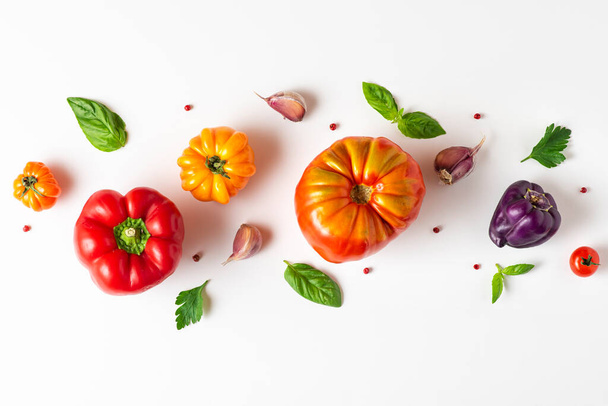Tomaattia, basilikaa, mausteita, pippuria, valkosipulia. Vegaaniruokaa. Värikäs orgaaninen tomaatti koostumus valkoisella taustalla. ylhäältä. ruoanlaitto käsite - Valokuva, kuva
