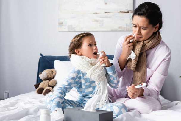 zieke moeder en dochter genezen met sprays in bed - Foto, afbeelding