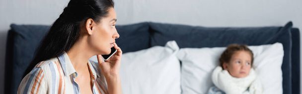 worried mother looking at diseased daughter while calling by mobile phone, banner - Foto, Bild