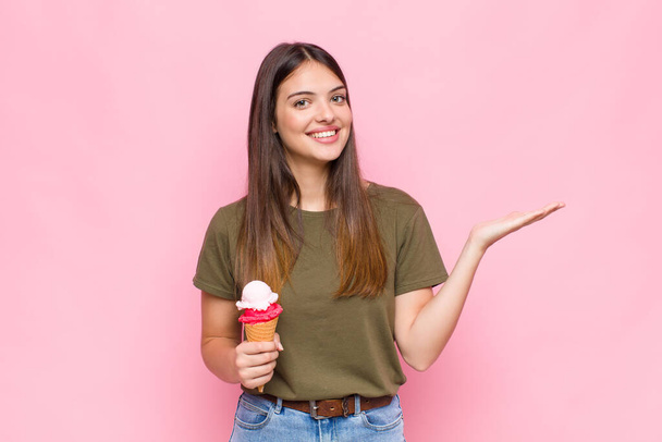 young pretty woman with an ice cream feeling happy, surprised and cheerful, smiling with positive attitude, realizing a solution or idea - Zdjęcie, obraz