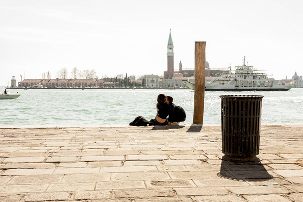 ヴェネツィア、イタリア- 2012年3月11日:ヴェネツィア、イタリア、ヨーロッパの遊歩道で抱き合って愛するカップル - 写真・画像
