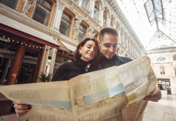 Beautiful couple on vacation using paper city map for directions. Travel vacation, leisure recreation lifestyle. - Zdjęcie, obraz