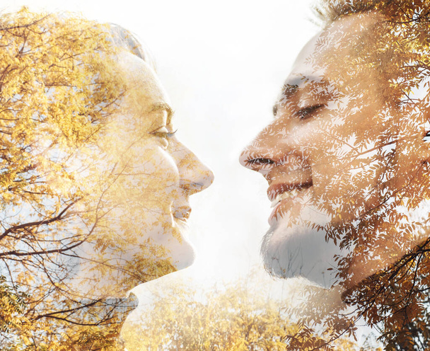 Portrait d'art à double exposition d'un jeune couple se regardant avec la texture d'arbres d'automne aux feuilles jaunes. Romantique, concept d'amour - Photo, image