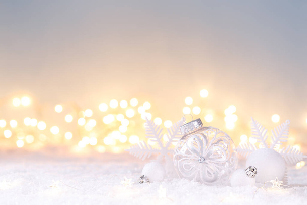 Noel kartı şablonu karların üzerinde beyaz süslemeler, ışıklar bokeh, boşluğu kopyala  - Fotoğraf, Görsel