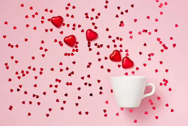 White mug and red hearts on color background, Valentines day concept - Фото, изображение
